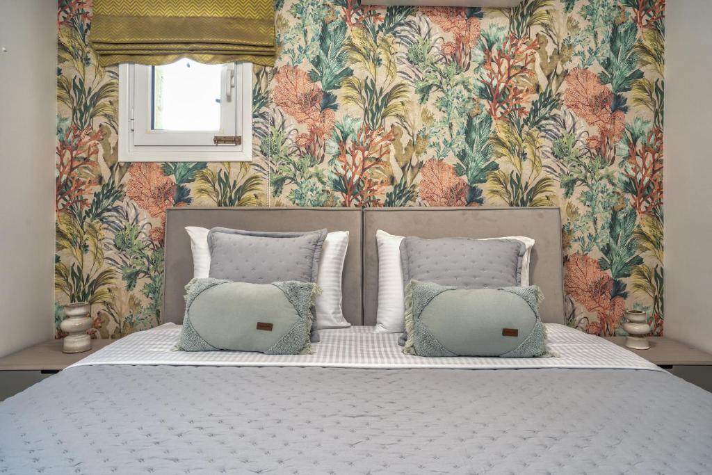 una camera da letto con un letto e carta da parati floreale di Suburban Elegant Studios a Città di Zante