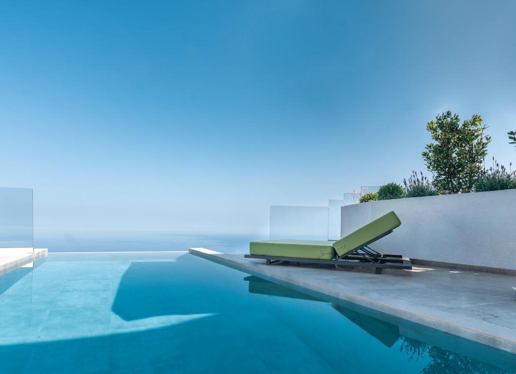 a pool with a lounge chair on the edge of it at Anadeo Villas & Suites in Exanthia