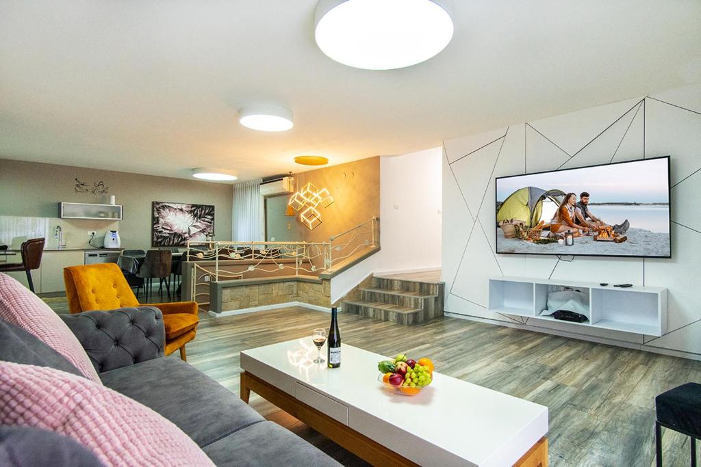 a living room with a couch and a tv at vilat hakohavim & Biktat HaKohavim in Qiryat Shemona