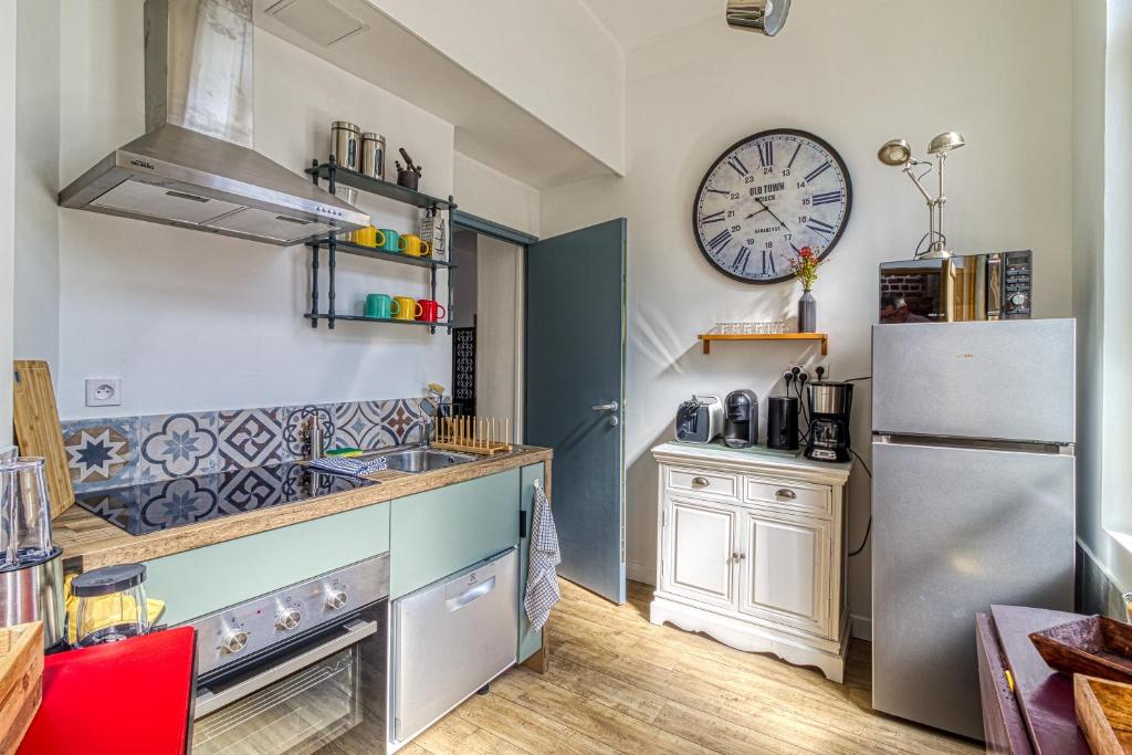 Il comprend une cuisine équipée d'un réfrigérateur et d'une horloge murale. dans l'établissement Le Saint-Pierre - Idéalement situé avec sauna, à Calais