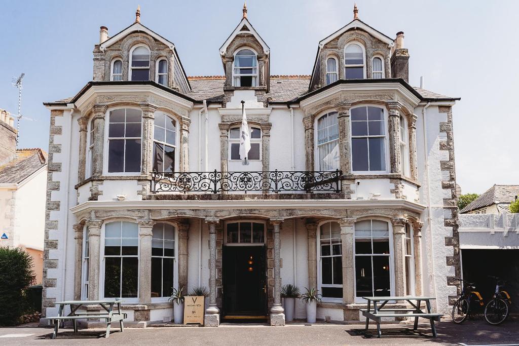 a large house with two benches in front of it at Hotel VARA in Truro