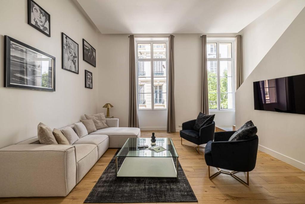Luxury 3 bedrooms apartment - 6 persons - rue Hoche في كان: غرفة معيشة مع أريكة وطاولة