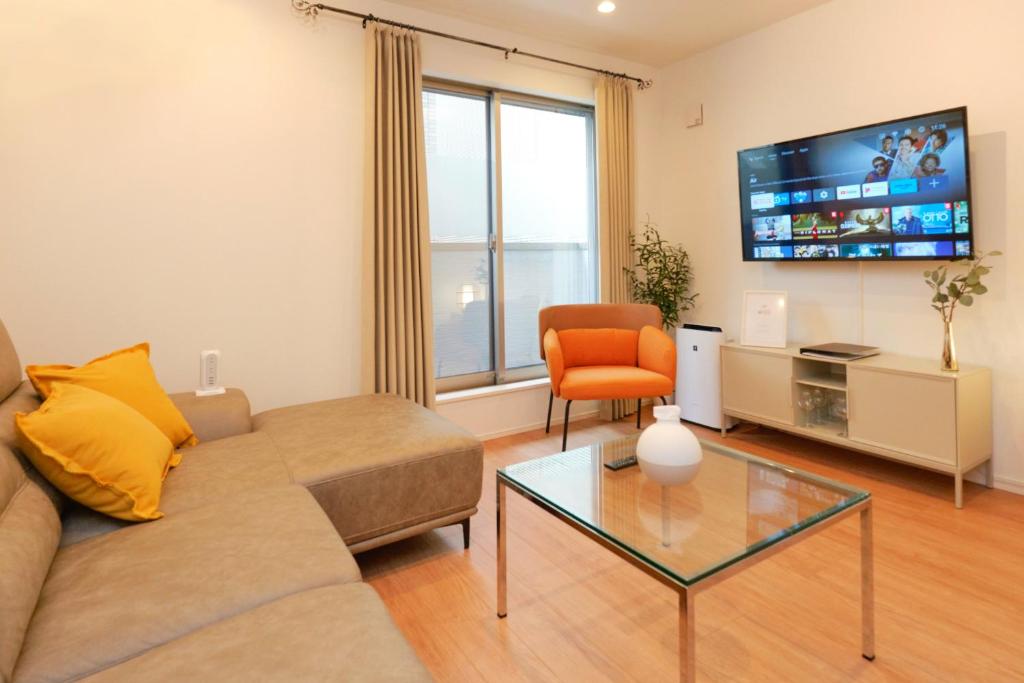 a living room with a couch and a chair and a tv at Shinjuku 1 Sta.・98㎡・4BR Entire Home Upscale Area in Tokyo