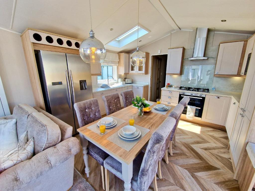una cucina e una sala da pranzo con tavolo e sedie in legno di Lula Lodge a Scarborough