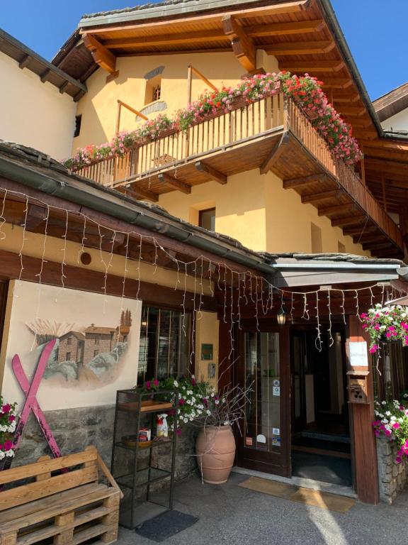 un edificio con un balcón con flores. en Hotel Coeur Du Village, en La Thuile