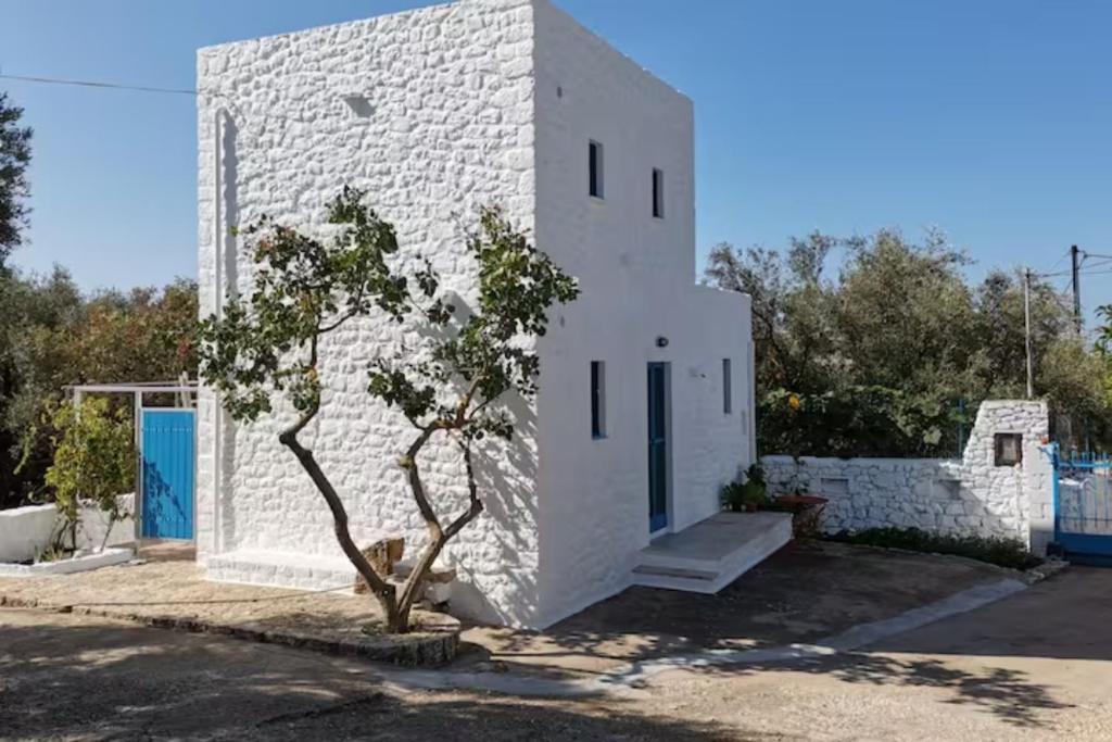 un edificio blanco con un árbol delante en Pyrgaki House, en Areopoli