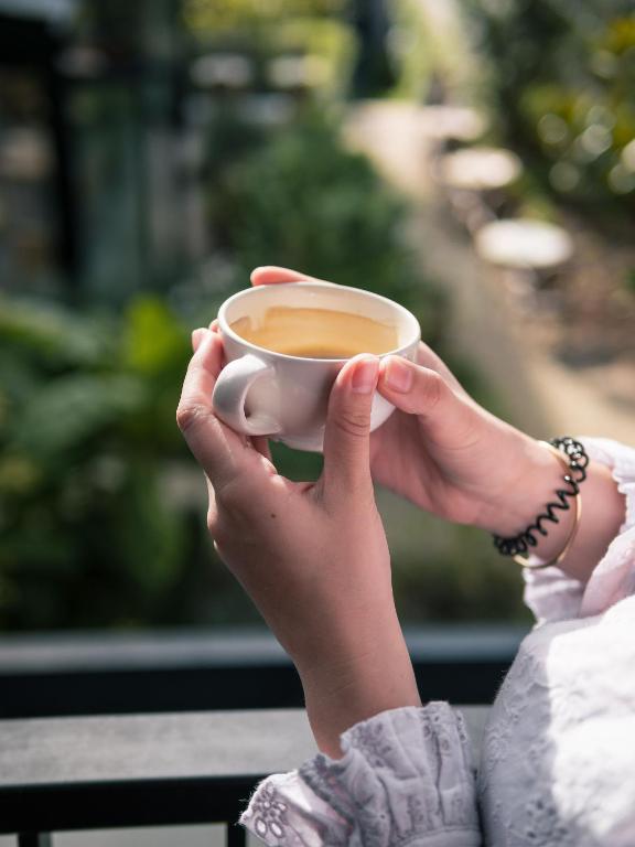 a woman is holding a cup of coffee at Deskopolitan House in Paris