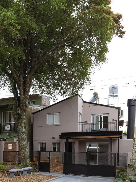 a white building with a tree in front of it at Bungalow Don Árbol in Colón