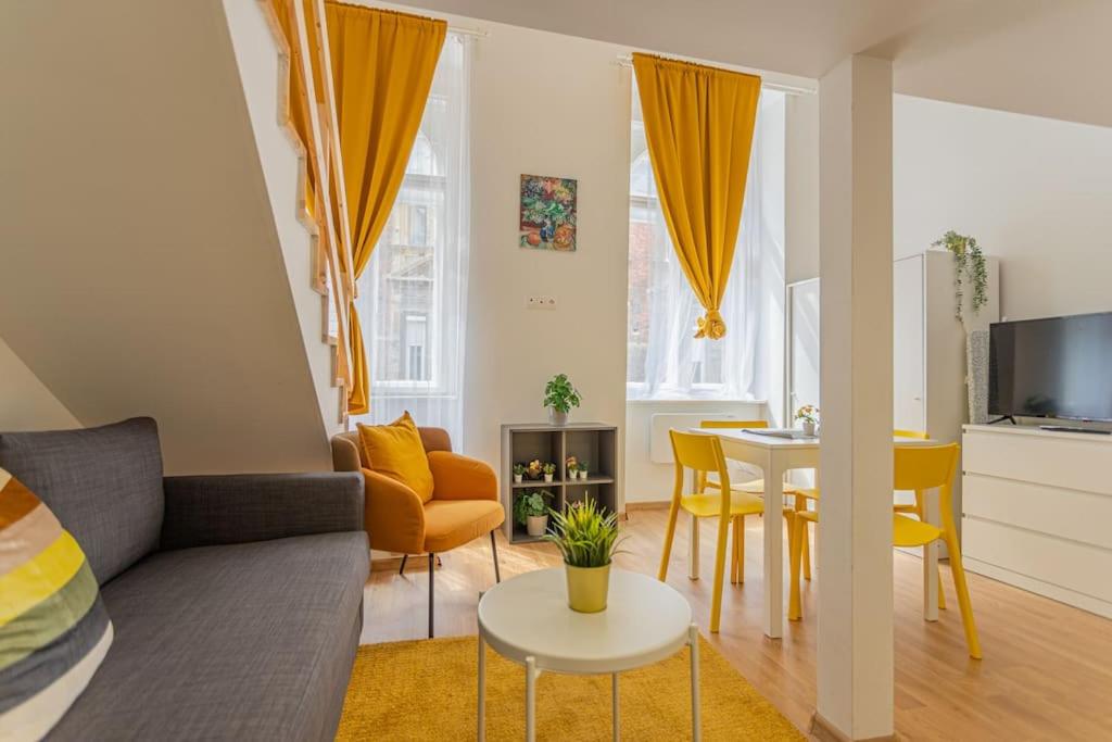 sala de estar con sofá y mesa en Two bedroom gallery flat in the Akacfa str., en Budapest
