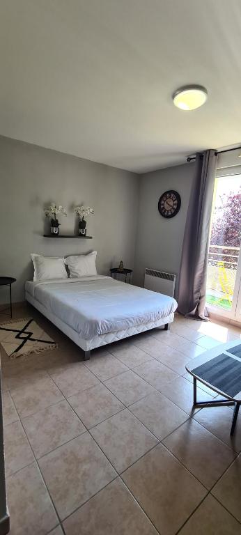 a bedroom with a white bed and a large window at Appartement DisneyLand Montevrain in Montévrain