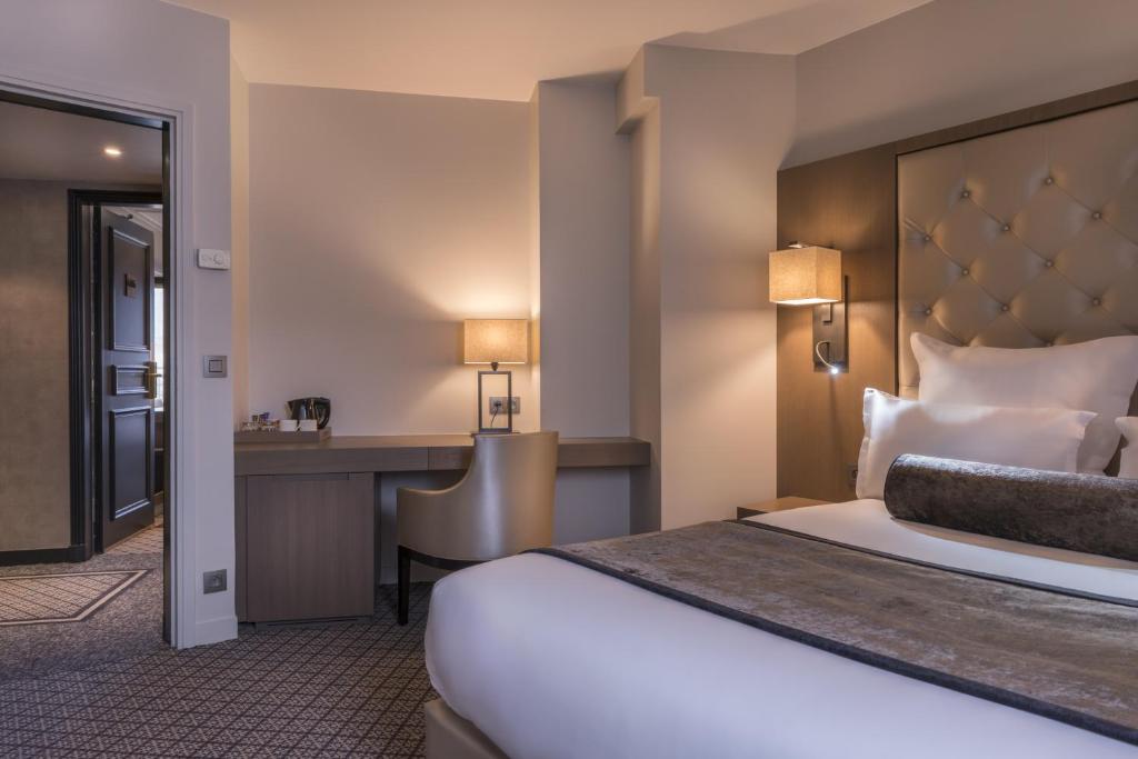 a hotel room with a bed and a desk at La Villa des Ternes in Paris