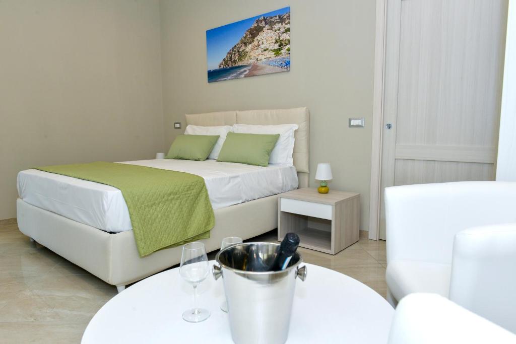 Schlafzimmer mit einem Bett und einem Tisch mit Weingläsern in der Unterkunft Ofelia House in Piano di Sorrento