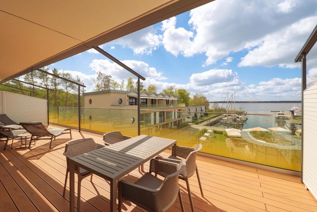 a balcony with a table and chairs and a large window at Appartements "Zum Leuchtturm" Hafen Rankwitz Insel Usedom in Rankwitz