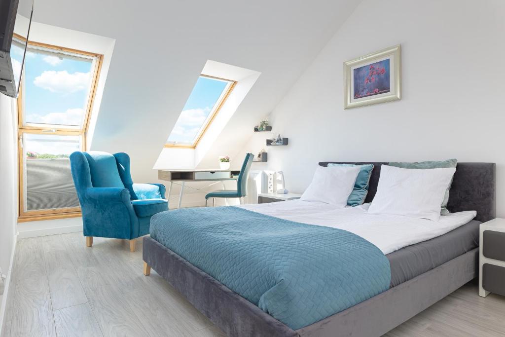 a bedroom with a bed and a blue chair at DreamHouse Apartament PORTOWY ul Wschodnia 12,Darłówko Wschodnie in Darłówko