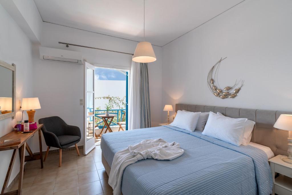 Schlafzimmer mit einem Bett, einem Schreibtisch und einem Balkon in der Unterkunft Hotel Matina in Kamari