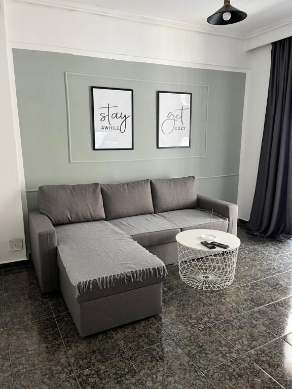 ein Wohnzimmer mit einem Sofa und einem Tisch in der Unterkunft Dimi Guest House in Peraia