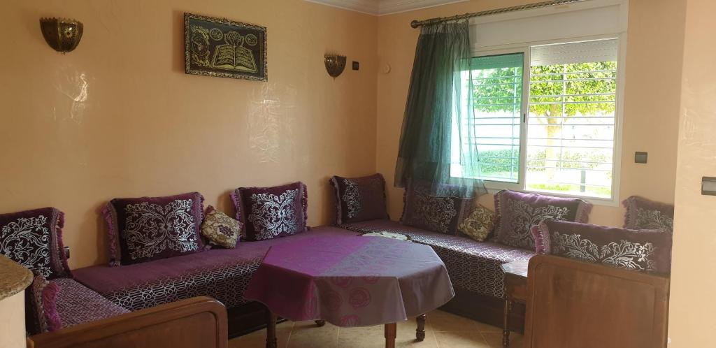 Habitación con sofá, mesa y ventana en Welcome Duplex en El Jadida