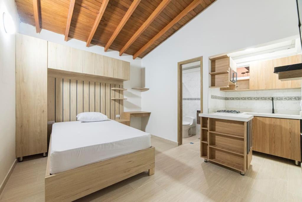 a bedroom with a bed and a sink and a bathroom at Discover urban life in the heart of Medellin 202 in Medellín