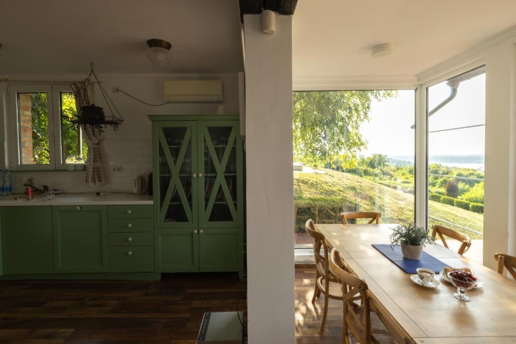 una cocina con armarios verdes, una mesa y una ventana en Vila Krcedin en Krčedin