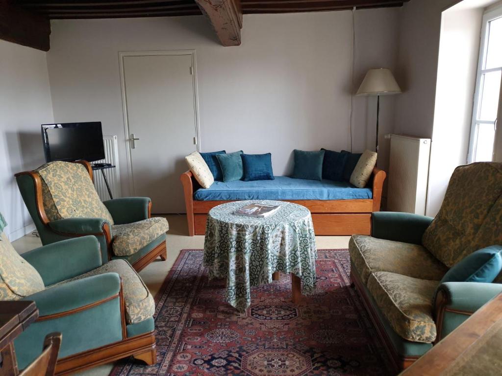 a living room with a blue couch and a table at La Barboulotte in Saint-Léger-Vauban