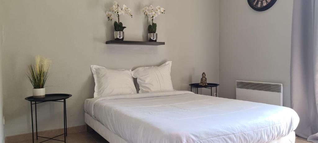 1 dormitorio con 1 cama blanca y 2 mesas en Appartement Proche DisneyLand Paris en Montévrain