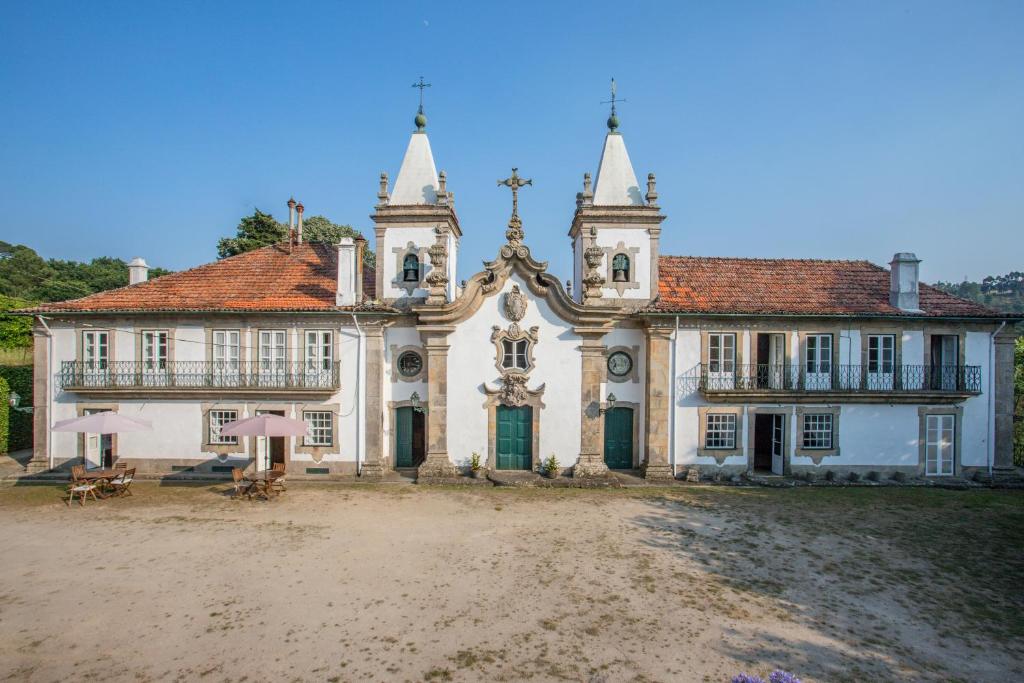 een groot wit gebouw met twee torens bij Outeiro Tuías - Manor House in Marco de Canavezes