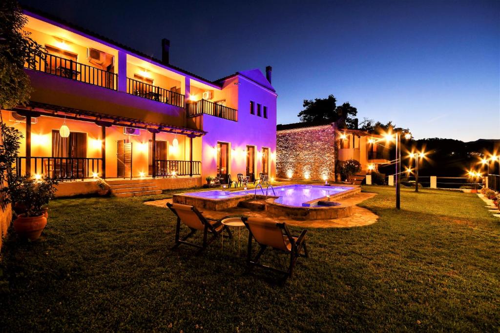 a house with a table and chairs in a yard at night at Guesthouse Amanitis Caesarea in Skíti