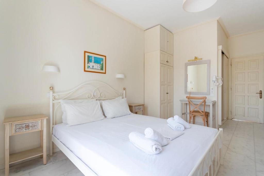a bedroom with a white bed with towels on it at Villa Kalomira in Spetses
