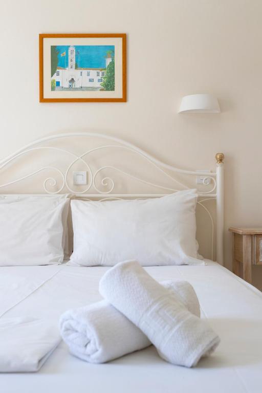 a white bed with two white towels on it at Villa Kalomira in Spetses