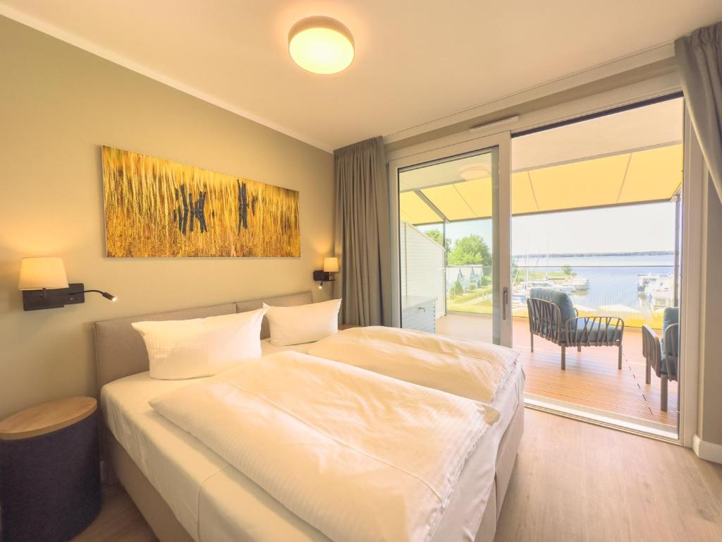a bedroom with a bed and a sliding glass door at Appartements "Zum Leuchtturm" Hafen Rankwitz Insel Usedom in Rankwitz