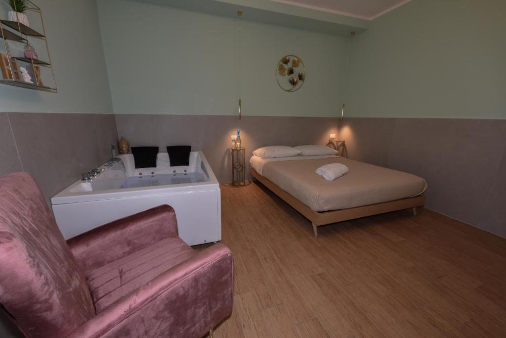 a bedroom with a bed and a tub and a couch at Suite tomà in Bisceglie
