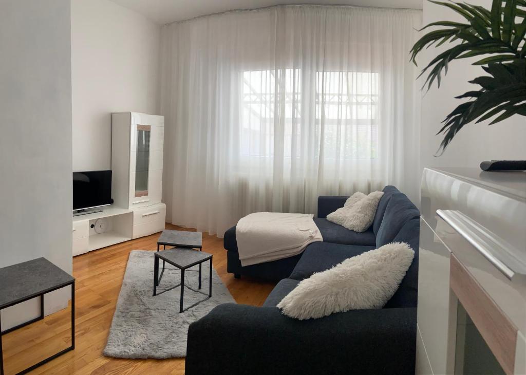 un soggiorno con divano blu e TV di Apartment Bambi a Mautern an der Donau