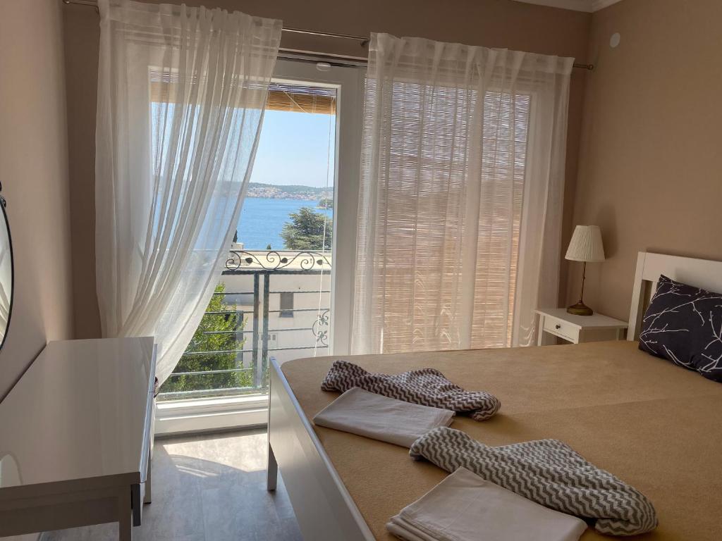 a bedroom with a bed and a large window at Jurič in Rogoznica