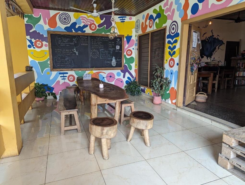 a restaurant with a table and stools and a chalkboard at Tumi Hostel in Kumasi