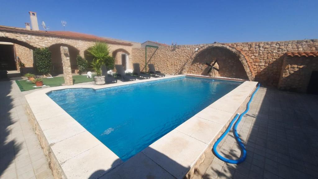 a swimming pool in front of a stone building at LOS ARCOS in Las Labores