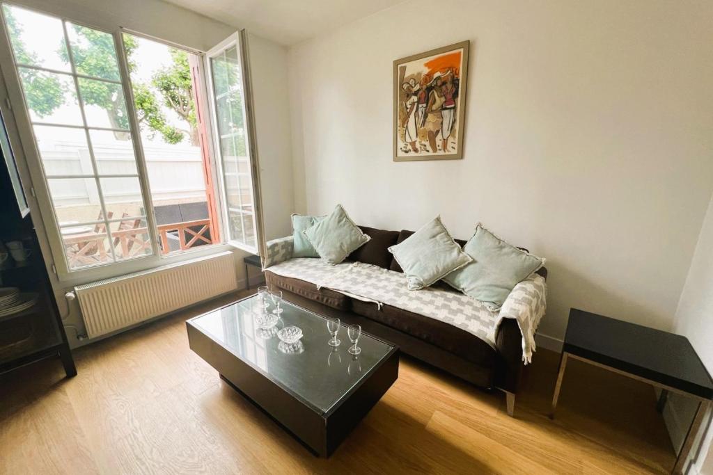 un salon avec un canapé et une table dans l'établissement Cosy Town house with its beautiful terrace, à Deauville