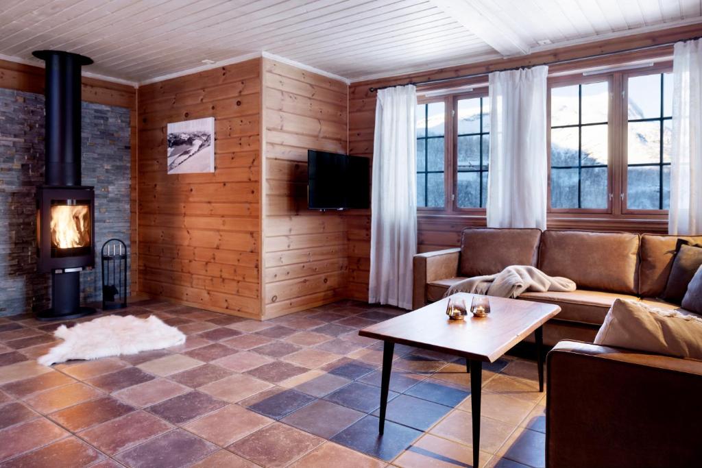 sala de estar con sofá y chimenea en Filefjellstuene, en Tyinkrysset