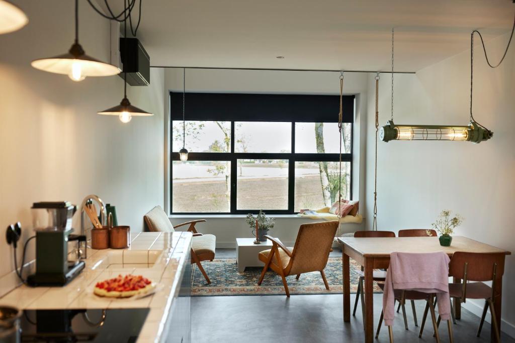 cocina y sala de estar con mesa y sillas en Suvelfabryk, en Lioessens