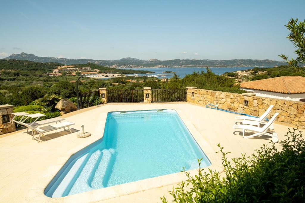 uma piscina com vista para a água em Villa Baja Sardinia con piscina e vista em Baja Sardinia