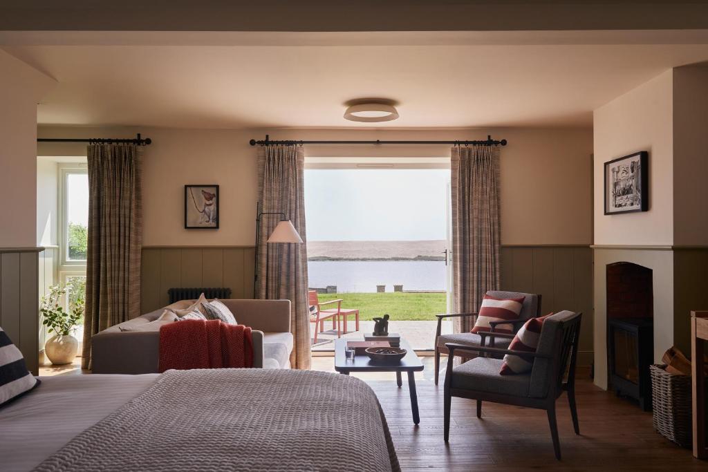 a bedroom with a bed and a living room with a window at Moonfleet Manor - A Luxury Family Hotel in Weymouth