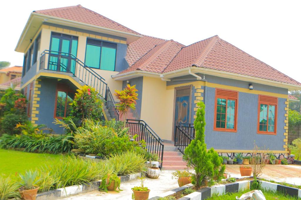 a house with a roof at Alice Gardens & Campsite in Entebbe