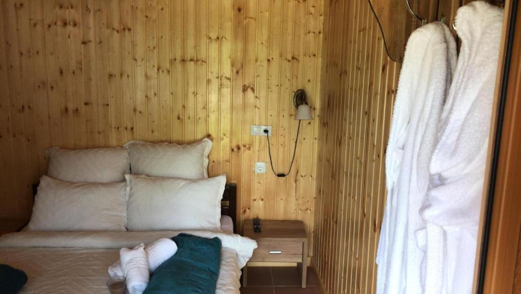 1 dormitorio con 1 cama y pared de madera en Casa OLD BRICK, en Ocna Şugatag