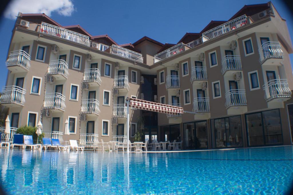 a large building with a pool in front of it at Remer Hotel in Fethiye
