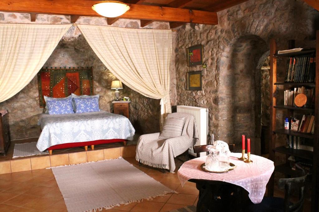 um quarto com uma cama e uma cadeira em Traditional stone build private studio em Verga Kalamata