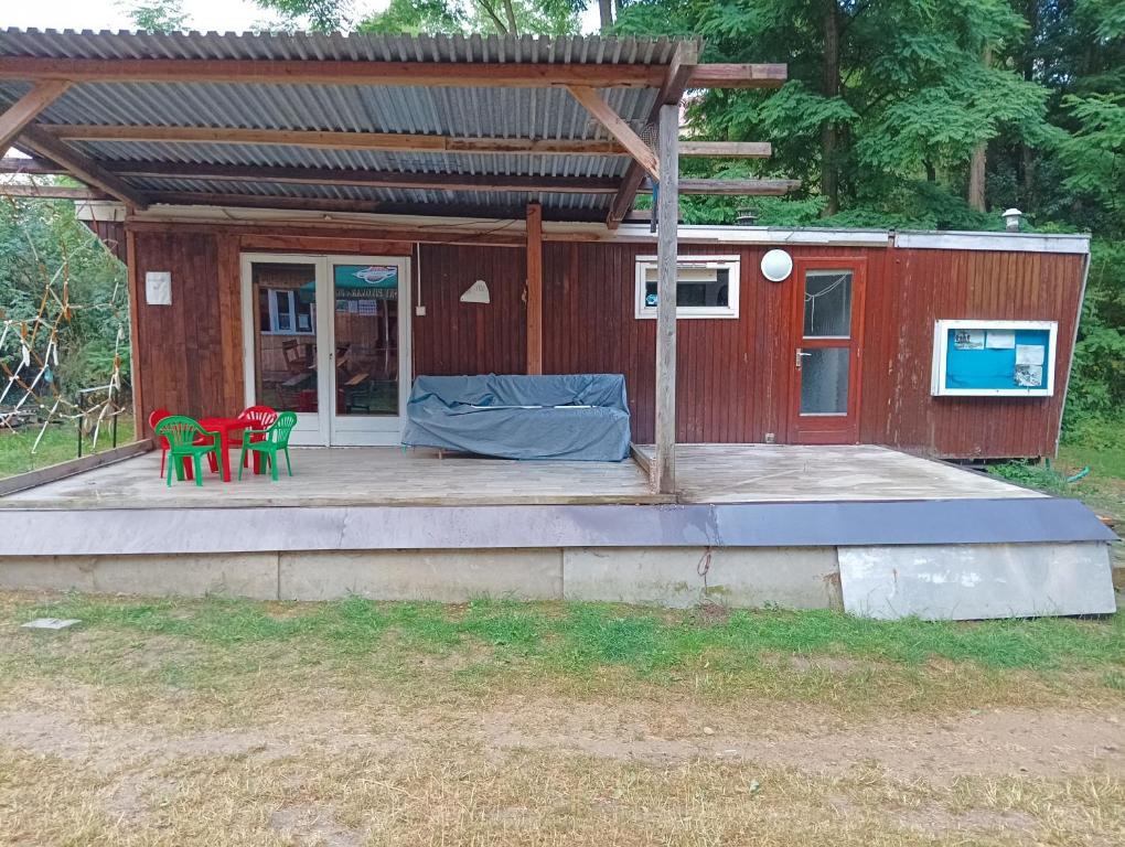 een klein rood huis met twee stoelen en een tafel bij Mobilheim in Mohelno
