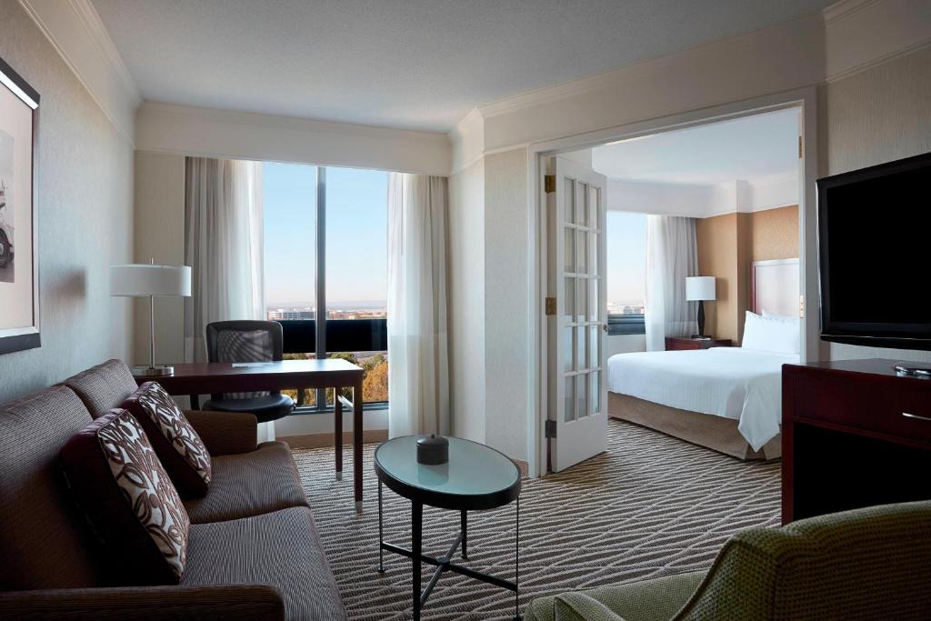 Habitación de hotel con cama y sala de estar. en Washington Dulles Marriott Suites, en Herndon