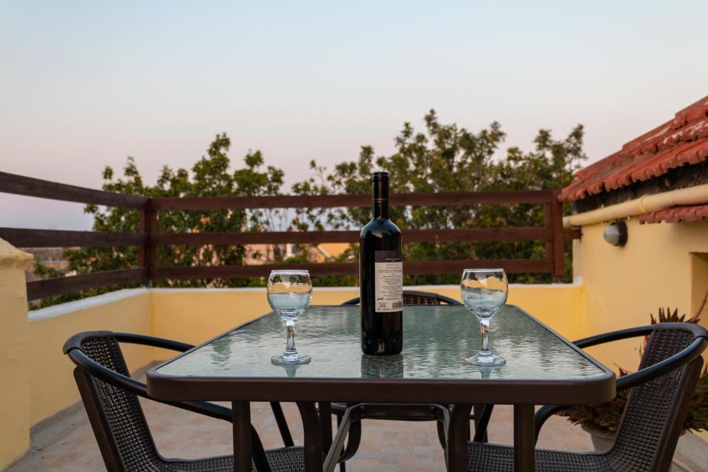 a bottle of wine sitting on a table with two glasses at Kathy's Apartments in Rhodes Town