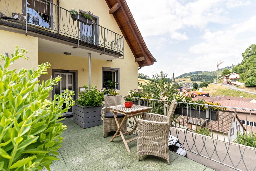 eine Terrasse mit einem Tisch und Stühlen auf dem Balkon in der Unterkunft am Kapellenberg in Bad Peterstal-Griesbach