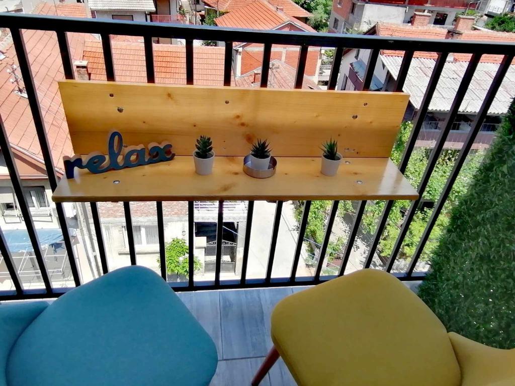 un balcón con 2 sillas y una mesa con plantas. en MD apartman Vranje FREE PARKING, en Vranje