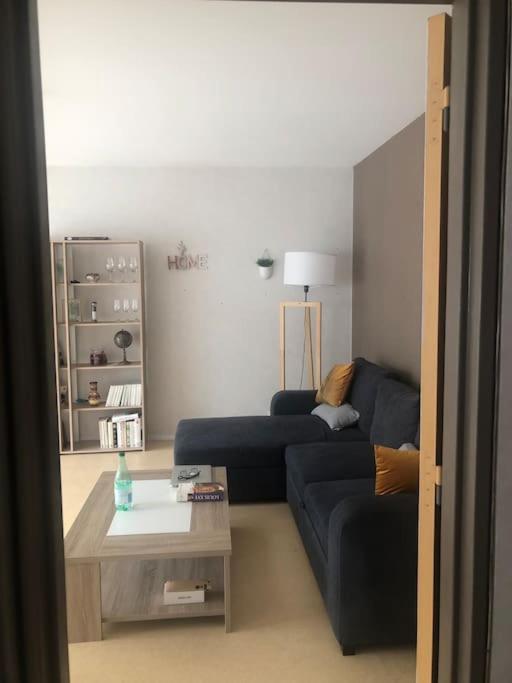 un salon avec un canapé bleu et une table basse dans l'établissement Appartement T2 meublé, à Limoges